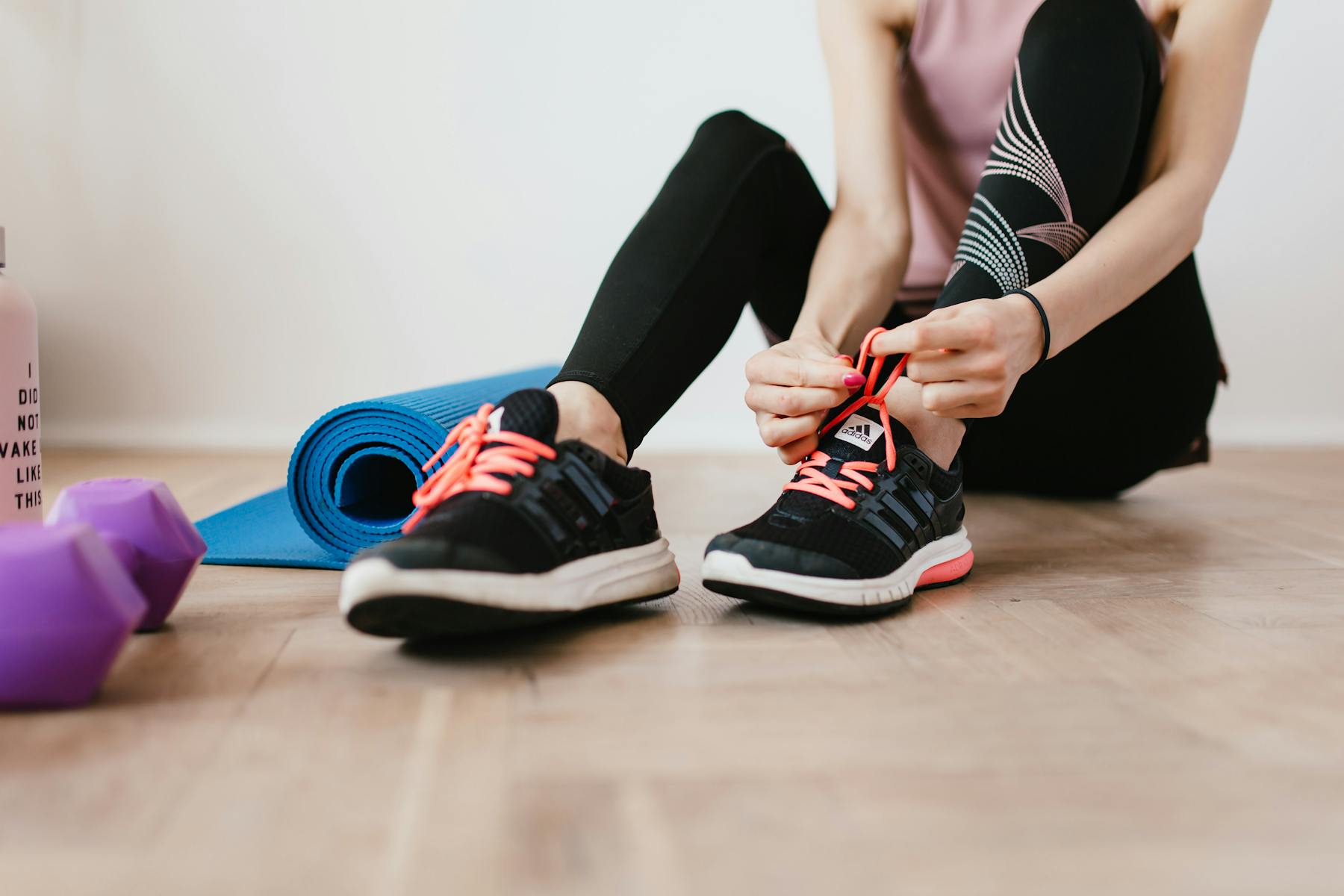 Person tying running shoes before home workout supporting personal training habits by Karola G https://www.pexels.com/@karola-g